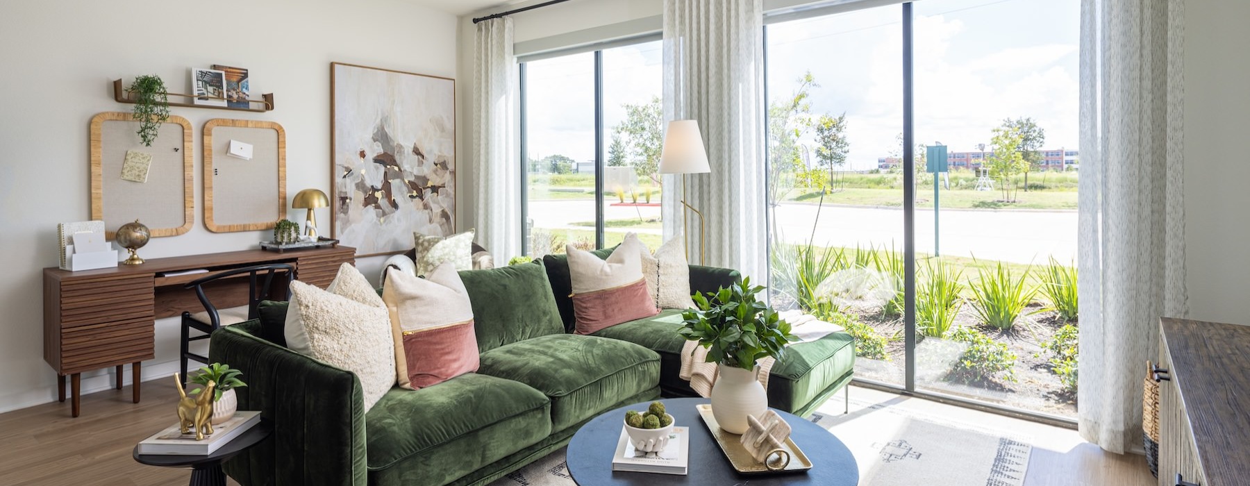 a living room with a green couch and a table with a chair