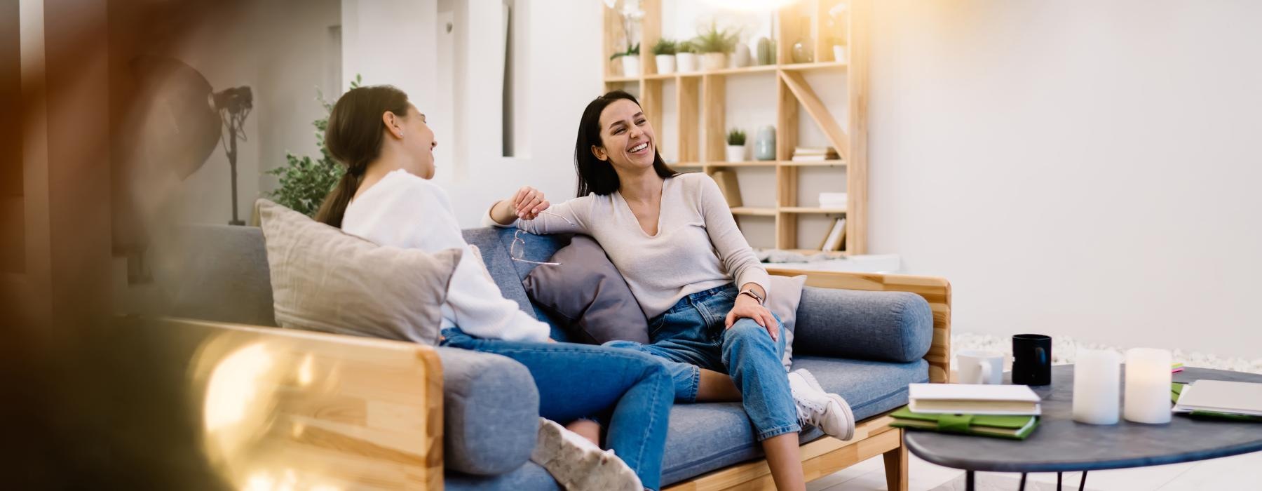 a person sitting on a couch with another woman on the lap