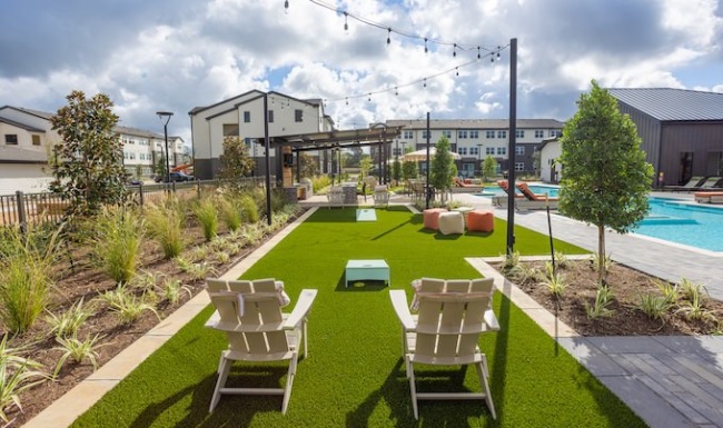 Gaming lawn next to the pool area with bistro lighting