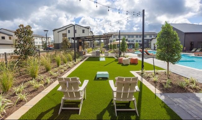 Gaming lawn next to the pool area with bistro lighting