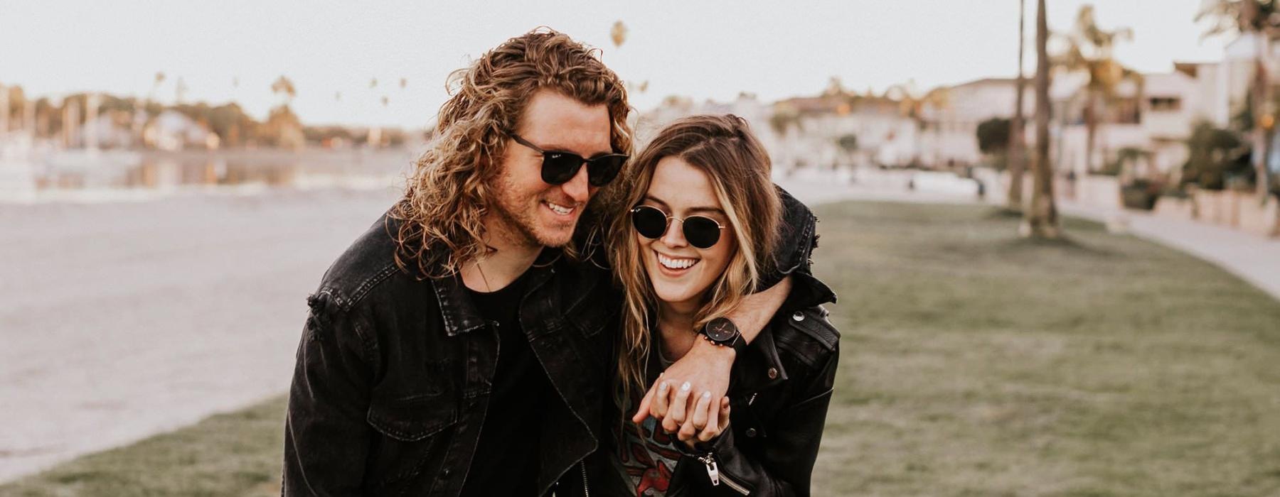 a couple walks on grassy area in open neighborhood lot